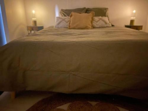 a large bed in a bedroom with two tables at Cosy - 2min Gare - work/fun in Bellegarde-sur-Valserine