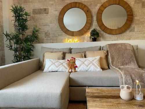 um urso de peluche sentado num sofá na sala de estar em Cosy, 2min Gare, work fun jacuzzi en juin em Bellegarde-sur-Valserine