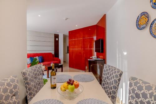 a dining room with a table with a bowl of fruit on it at Monicca Collection Suites and Residences in Albufeira