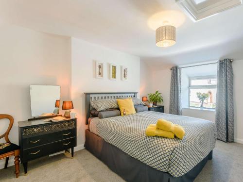 a bedroom with a bed with yellow pillows on it at 2 bed in Llanrwst 83295 in Llanrwst
