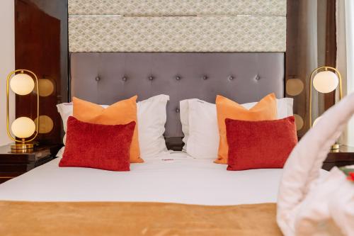 a bedroom with a bed with orange and white pillows at Monicca Collection Suites and Residences in Albufeira