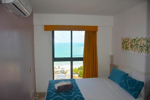 1 dormitorio con cama y ventana grande en Aptos Privativos Vista Mar Hotel Paradise Flat, en Natal