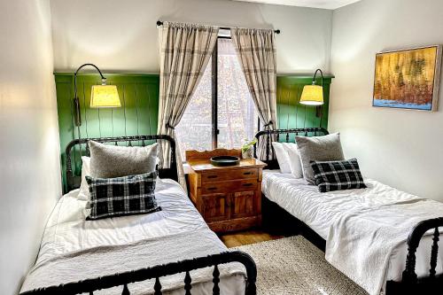 duas camas num quarto com paredes verdes em Ottaquechee Overlook em Quechee