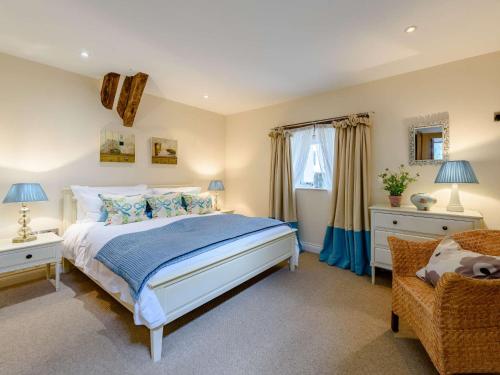 6 bed in Barnstaple 85615 في Tawstock: غرفة نوم بسرير كبير وكرسي