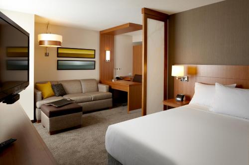 um quarto de hotel com uma cama e um sofá em Hyatt Place at The Hollywood Casino Pittsburgh South em Washington