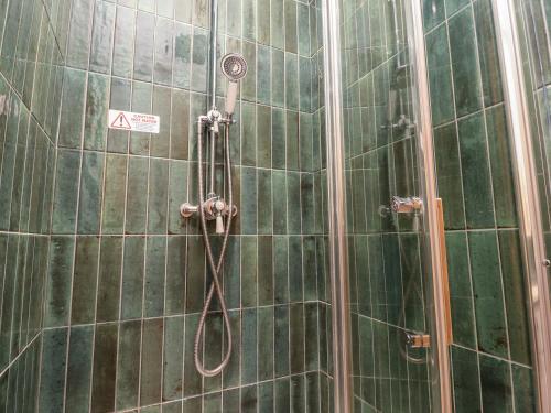 a shower in a bathroom with green tiles at Malham in Skipton