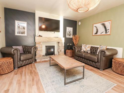 a living room with two couches and a fireplace at Austwick in Skipton
