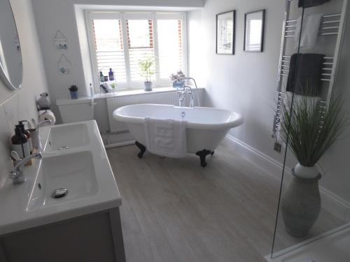 a white bathroom with a tub and a window at The Skreen in Builth Wells