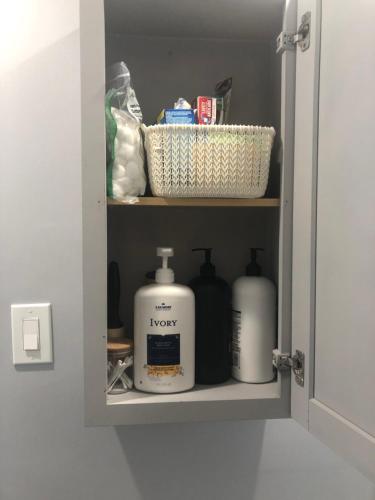 a shelf in a bathroom with toiletries on it at Spotless 2 Bedroom Suite in Winnipeg in Winnipeg