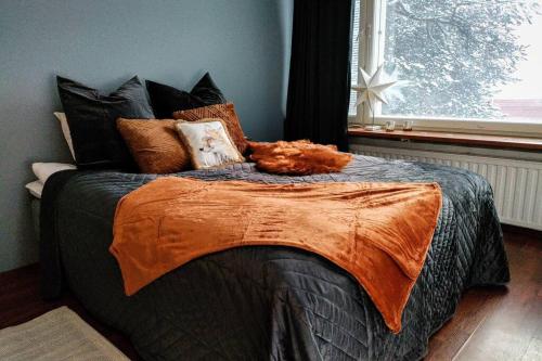 um quarto com uma cama com almofadas e uma janela em Arctic Foxy Studio em Rovaniemi