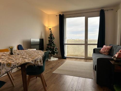 a living room with a christmas tree and a table at Roosevelt Cosy 2BR Easy Access to Paris Free parking in Saint-Germain-en-Laye