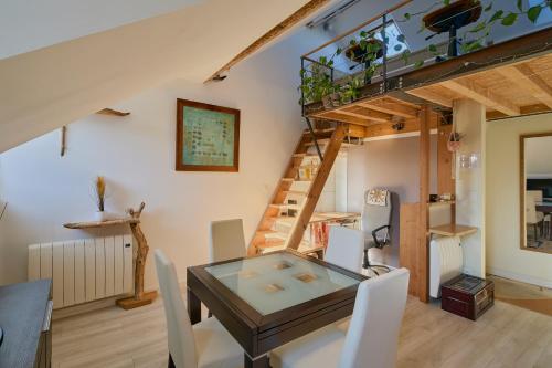 une salle à manger avec une table en verre et des chaises blanches dans l'établissement Bel appartement, mezzanine, calme, 2 coins bureaux - Home'ponopono, à Nantes