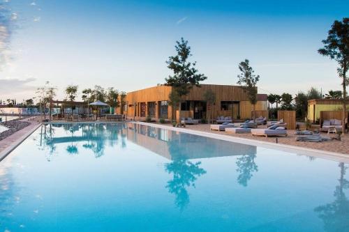 a large swimming pool with blue water in a resort at Villa Marrakech piscine privée vue sur Golf&Atlas in Marrakesh