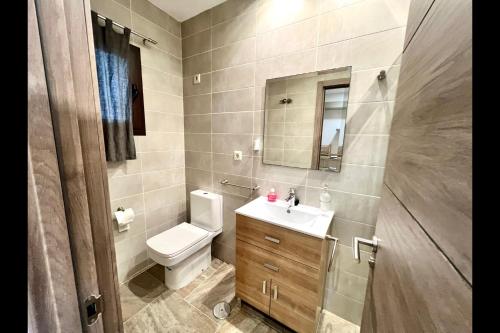 W łazience znajduje się toaleta, umywalka i lustro. w obiekcie Mijas Costa - Beachside Apartment-B w mieście Mijas Costa