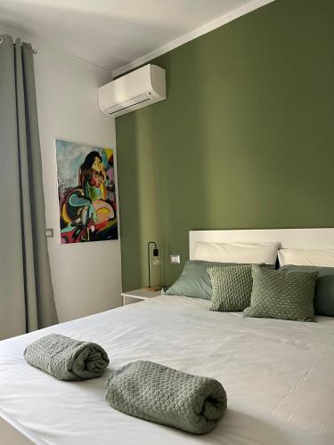 una camera da letto con un grande letto bianco e pareti verdi di La Veronica Apartment a Napoli