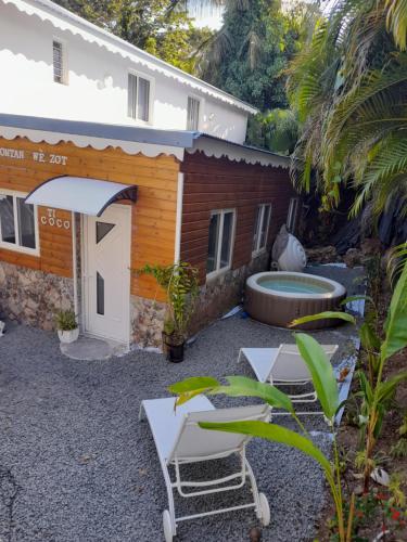 a backyard with two chairs and a swimming pool at VillaBadlou "Lodge Ti-Kaco Vanille" in Trois-Rivières