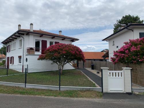 ein weißes Haus mit einem Zaun davor in der Unterkunft Résidence « les Gets » Location T4 Vieux-Boucau-Les-Bains in Vieux-Boucau-les-Bains