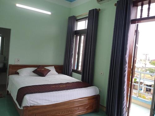 a bedroom with a bed and a large window at Tam Coc Village in Ninh Binh