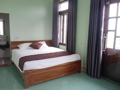 una camera con un letto in una stanza con finestre di Tam Coc Village a Ninh Binh