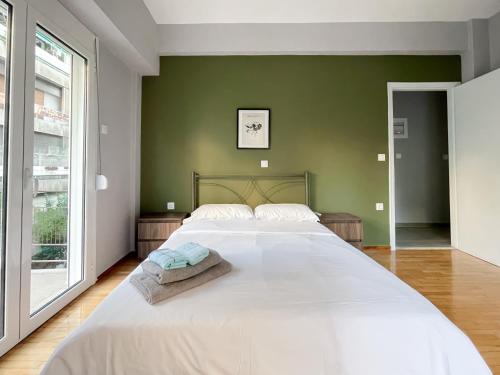 um quarto com uma grande cama branca e uma parede verde em 4-bedroom Dream Apartment em Atenas