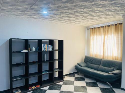 Nouadhibou Guest House في نواذيبو: غرفة معيشة مع أريكة ورف كتاب