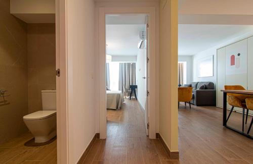 Un baño con inodoro y un dormitorio. en Apartamentos 1 Abril, en Málaga