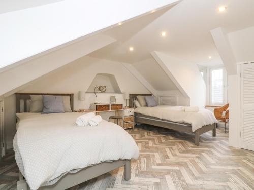 a attic bedroom with two beds and a staircase at Chy An Mor in Mevagissey