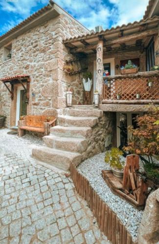 a stone house with stairs leading up to a building at Casas do Lobo in Tarouca