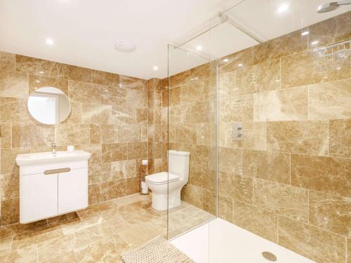 a bathroom with a toilet and a glass shower at 3 bed in Bedale 88242 in Well