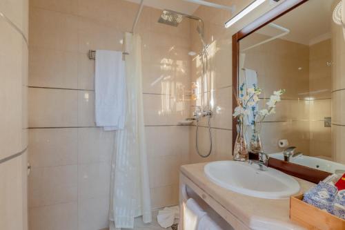a bathroom with a sink and a shower at Monicca Collection Suites and Residences in Albufeira