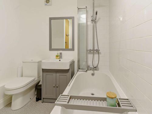 uma casa de banho branca com uma banheira, um lavatório e um WC. em 3 bed in Pendine 82383 em Pendine