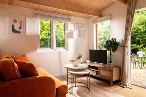 a living room with a couch and a table with a tv at Copperbeech - Luxury Holiday with Private Hottub in Blandford Forum