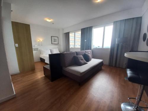 a living room with a couch and a bed at STD - Anora Spaces - Stadium Alphaville in Barueri