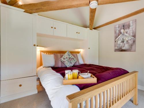 1 bed property in Bedale G0044 في Hornby: غرفة نوم مع سرير عليه صينية مشروبات