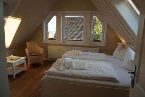 ヴィーク・アウフ・フェールにあるFiete Deppe Hausのベッドルーム1室(大きな白いベッド1台、窓2つ付)