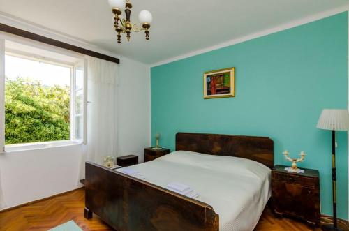 a bedroom with a bed and a blue wall at Apartment Pavo in Dubrovnik