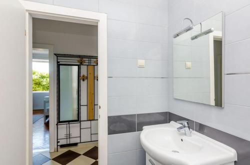 a white bathroom with a sink and a mirror at Apartment Pavo in Dubrovnik
