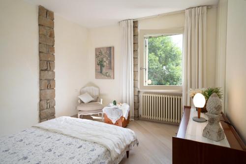 een slaapkamer met een bed en een raam bij VILLA INFINITY - Regarda Travel in Bardolino