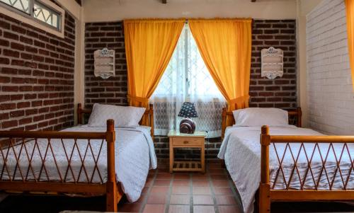 two beds in a room with a window at Las villas de Yoly in Playas