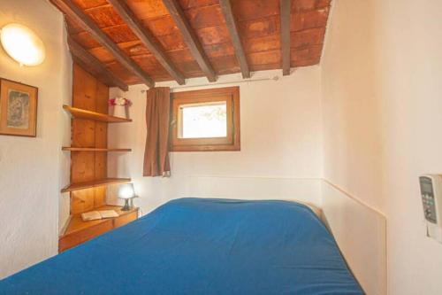 - une chambre avec un lit bleu et une fenêtre dans l'établissement Bellavista, à Campese
