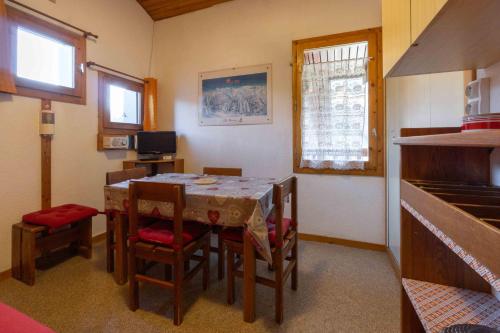 une cuisine avec une table et des chaises dans une pièce dans l'établissement Appart Au Pied Des Pistes, à La Plagne Tarentaise