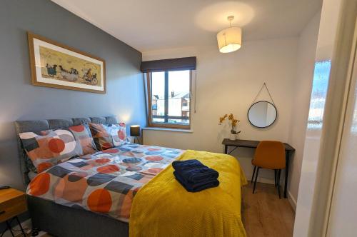 een slaapkamer met een bed en een bureau met een spiegel bij Stunning Modern Coventry City Centre Apartment in Coventry