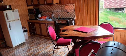 a kitchen with a table with a book on it at Cabaña piedra azul in Dalcahue