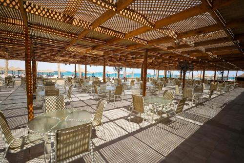 een groep tafels en stoelen op een strand bij Blend Club Aqua Resort in Hurghada