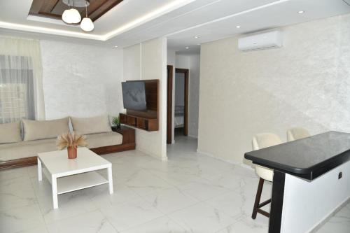 a living room with a couch and a tv at Stylish 3-Bedroom Flat in Kenitra Center Ville with Parking & Comfort in Kenitra