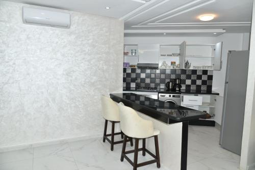 uma cozinha com um balcão preto e electrodomésticos brancos em BRAND NEW! 3 Bedroom Apartment in the Heart of Kenitra em Kenitra