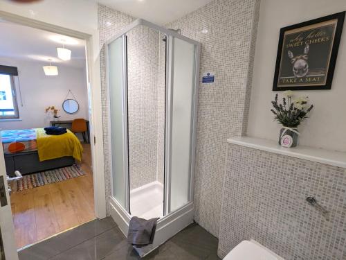 uma casa de banho com um chuveiro e uma porta de vidro em Stunning Modern Coventry City Centre Apartment em Coventry