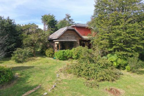 an old house in the middle of a yard at Suite con jacuzzi y bellas vistas in Lanalhue Lake