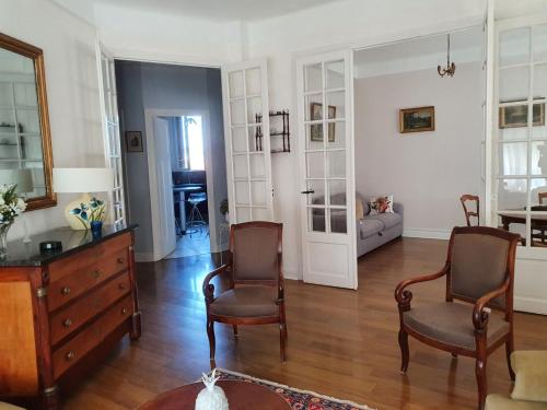 - un salon avec deux chaises et une commode dans l'établissement Spacieux 80 m2 Cœur de Vichy proche des Thermes, à Vichy