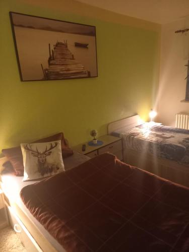 a bedroom with two beds and a picture on the wall at Monteur- und Ferienwohnung Waldrauschen in Fehrenbach